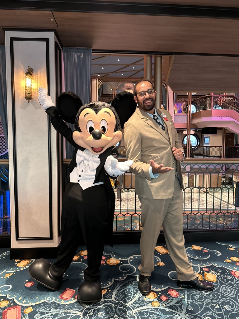 Augusto ao lado de um personagem da Disney a bordo