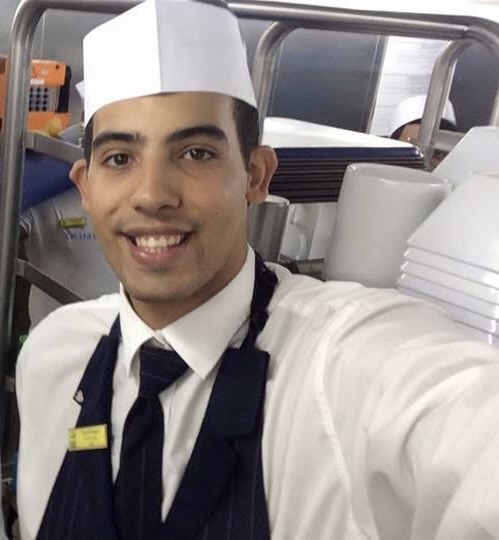 Augusto como garçom, de uniforme